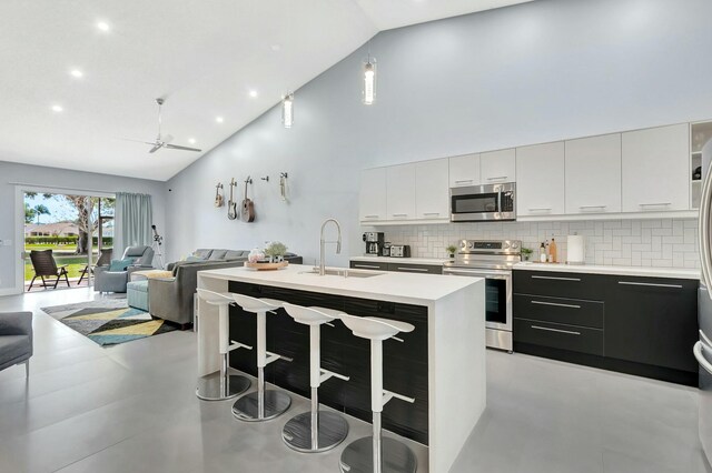 9238 E Vineland Ct E Unit E, Boca Raton, FL 33496 - kitchen featuring high vaulted ceiling, light countertops, appliances with stainless steel finishes, a kitchen breakfast bar, and open floor plan