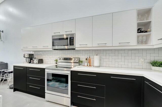9238 E Vineland Ct E Unit E, Boca Raton, FL 33496 - kitchen featuring backsplash, white cabinetry, appliances with stainless steel finishes, light countertops, and dark cabinets