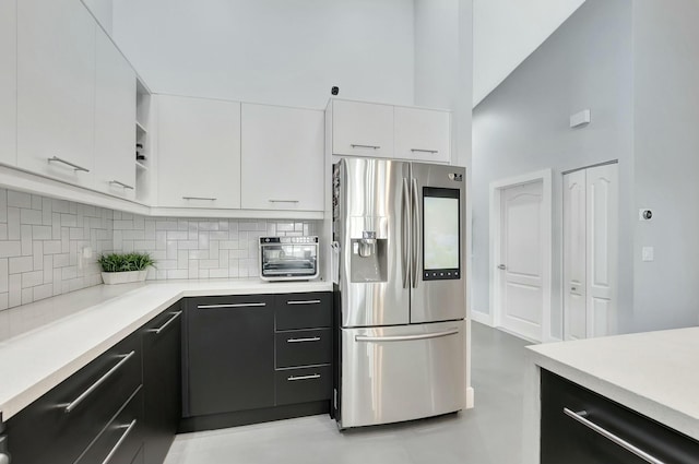 9238 E Vineland Ct E Unit E, Boca Raton, FL 33496 - kitchen featuring light countertops, white cabinets, stainless steel fridge with ice dispenser, and tasteful backsplash