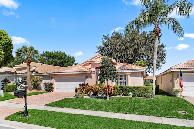 7267 Modena Dr, Boynton Beach, FL 33437 - mediterranean / spanish-style house with a tiled roof, a front yard, stucco siding, decorative driveway, and a garage