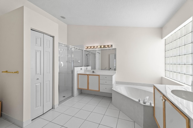 7267 Modena Dr, Boynton Beach, FL 33437 - bathroom featuring two vanities, a shower stall, a textured ceiling, a garden tub, and tile patterned floors