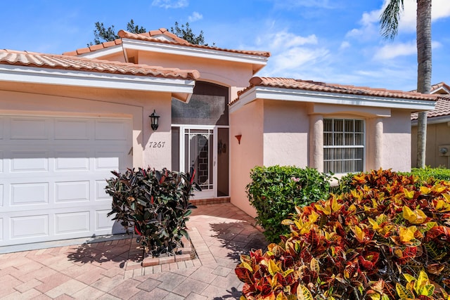 7267 Modena Dr, Boynton Beach, FL 33437 - view of front facade featuring stucco siding, a tiled roof, driveway, and a garage