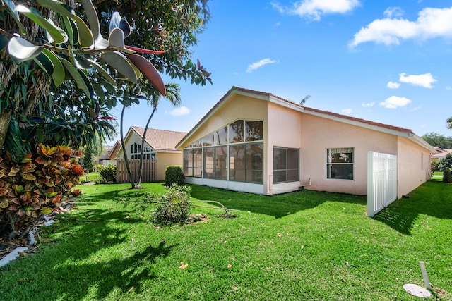 7267 Modena Dr, Boynton Beach, FL 33437 - rear view of property featuring stucco siding, a lawn, fence, and a sunroom