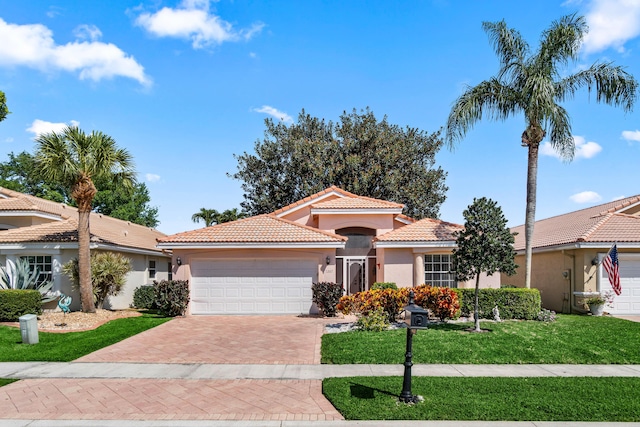 7267 Modena Dr, Boynton Beach, FL 33437 - mediterranean / spanish-style house featuring a tiled roof, a front yard, stucco siding, a garage, and driveway