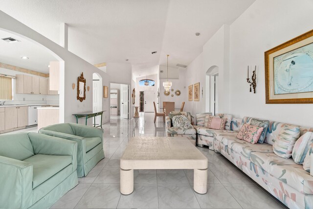 7267 Modena Dr, Boynton Beach, FL 33437 - living area with arched walkways, visible vents, high vaulted ceiling, and a notable chandelier