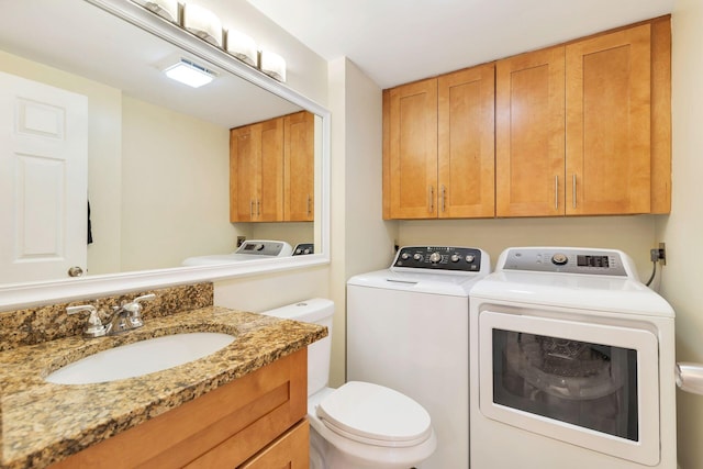 half bathroom featuring toilet, vanity, and separate washer and dryer