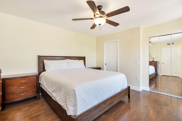 bedroom with baseboards, visible vents, dark wood finished floors, ceiling fan, and a textured ceiling