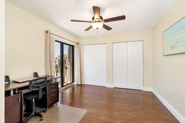 office space with dark wood-type flooring, a ceiling fan, and baseboards