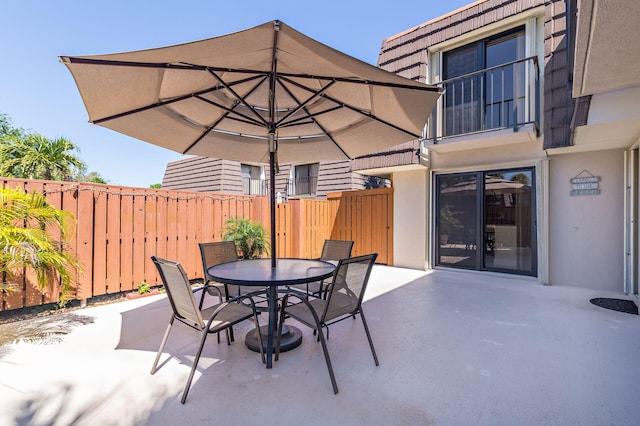 view of patio with outdoor dining area and fence