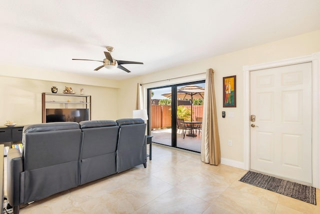 living room with baseboards and a ceiling fan