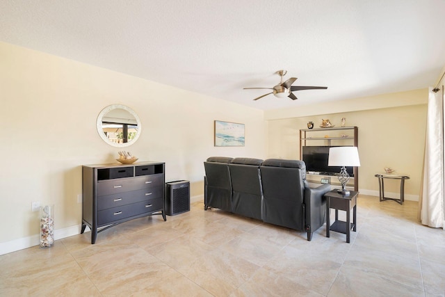 living room with baseboards and ceiling fan