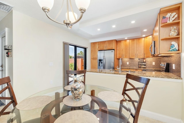 dining space featuring a raised ceiling, recessed lighting, visible vents, and a chandelier