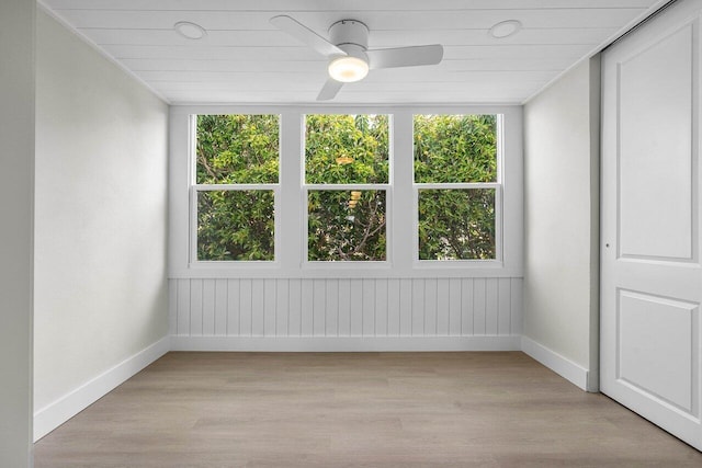 spare room with light wood-style floors, baseboards, and ceiling fan