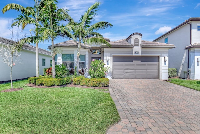 7855 Wildflower Shores Dr, Delray Beach, FL 33446 - ranch-style house featuring a front lawn, decorative driveway, a garage, and stucco siding