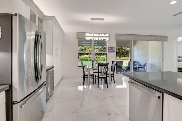 7855 Wildflower Shores Dr, Delray Beach, FL 33446 - kitchen with visible vents, marble finish floor, dark countertops, white cabinetry, and appliances with stainless steel finishes