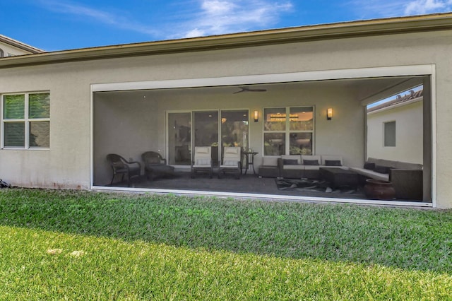 7855 Wildflower Shores Dr, Delray Beach, FL 33446 - back of property with a ceiling fan, a sunroom, stucco siding, a lawn, and an outdoor hangout area