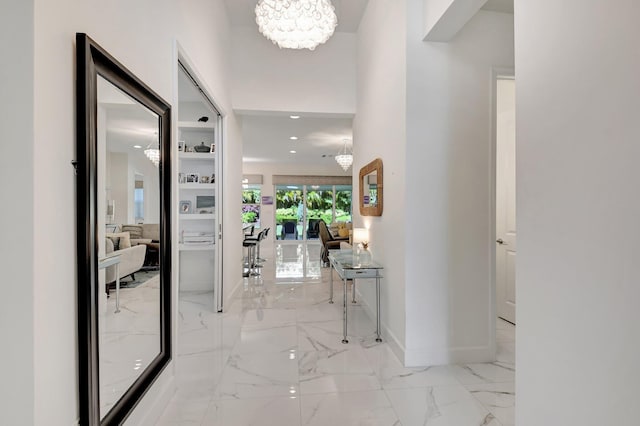 7855 Wildflower Shores Dr, Delray Beach, FL 33446 - hall featuring an inviting chandelier, baseboards, and marble finish floor