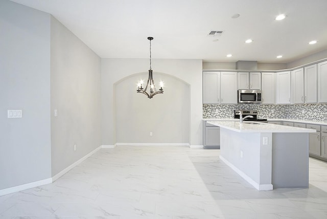 kitchen featuring a notable chandelier, marble finish floor, tasteful backsplash, stainless steel appliances, and baseboards