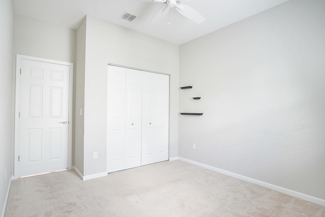 unfurnished bedroom featuring a closet, light carpet, baseboards, and visible vents