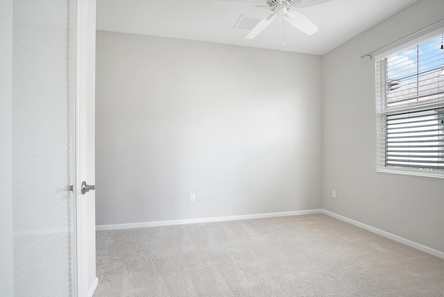 unfurnished room with a ceiling fan, light colored carpet, and baseboards