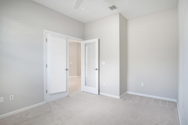 unfurnished bedroom featuring ceiling fan, carpet, visible vents, and baseboards