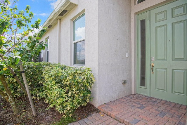 entrance to property with stucco siding