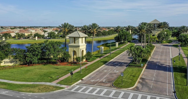 surrounding community with a water view and a lawn