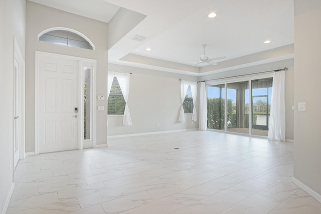 foyer entrance featuring visible vents, marble finish floor, a ceiling fan, and baseboards