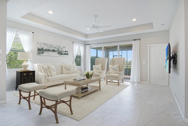 11243 SW Parkside Dr, Port Saint Lucie, FL 34987 - living area featuring a tray ceiling, plenty of natural light, baseboards, and a ceiling fan