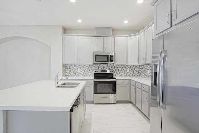 kitchen featuring decorative backsplash, marble finish floor, stainless steel appliances, and a sink