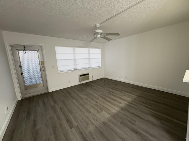 unfurnished living room featuring plenty of natural light, a wall mounted AC, ceiling fan, and dark wood-style flooring
