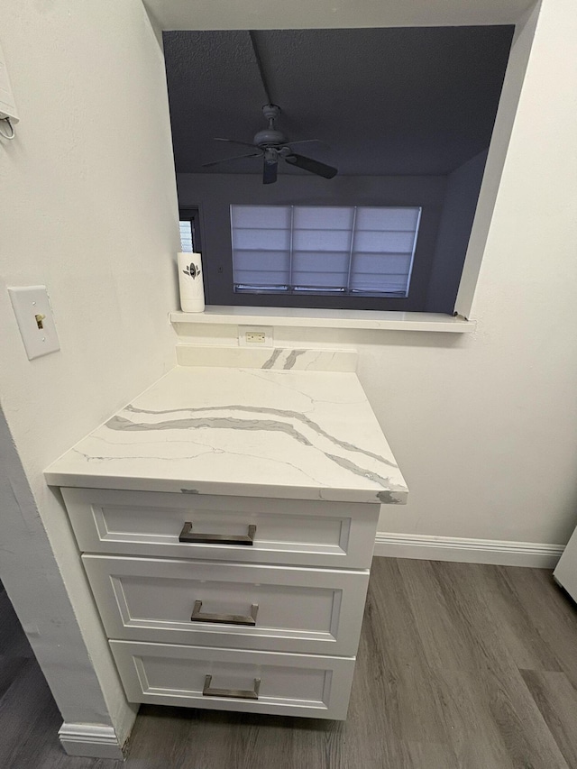 room details with baseboards, wood finished floors, and a ceiling fan
