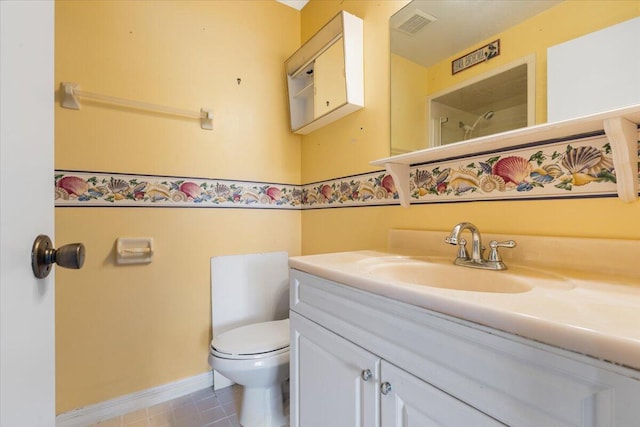 bathroom featuring visible vents, toilet, baseboards, walk in shower, and vanity