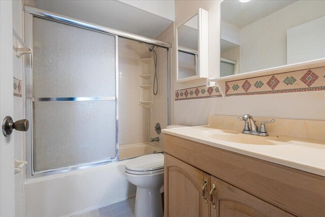 bathroom featuring bath / shower combo with glass door, vanity, and toilet