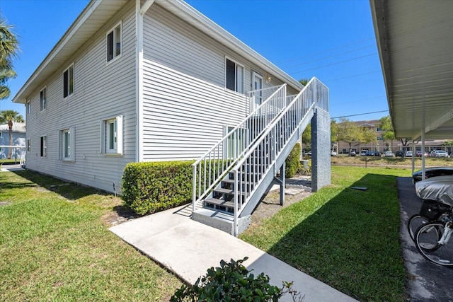 view of side of property with a lawn and stairs