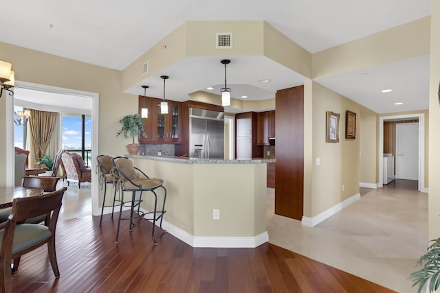3620 Gardens Pkwy Unit 1001B, Palm Beach Gardens, FL 33410 - kitchen featuring stainless steel built in refrigerator, a peninsula, a kitchen breakfast bar, glass insert cabinets, and decorative backsplash