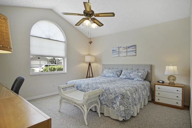 carpeted bedroom featuring a textured ceiling, lofted ceiling, baseboards, and ceiling fan