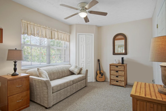 living area featuring a ceiling fan and carpet flooring