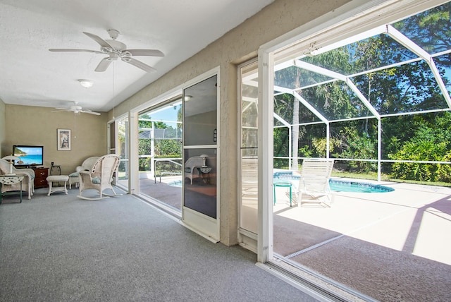 unfurnished sunroom featuring a ceiling fan