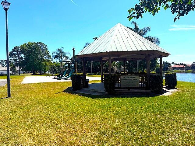 view of property's community featuring a gazebo, a yard, playground community, and a water view