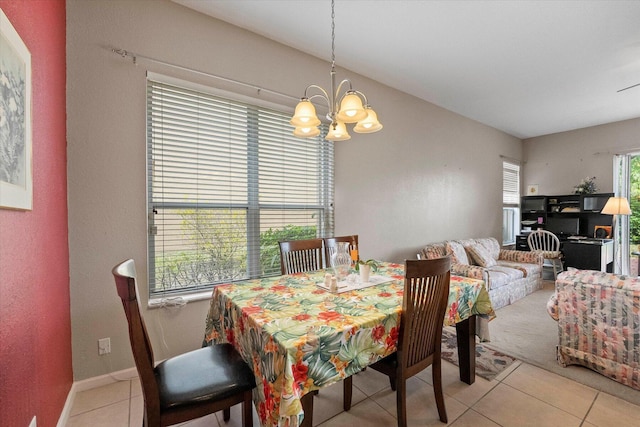 dining room featuring light tile patterned floors, baseboards, and an inviting chandelier