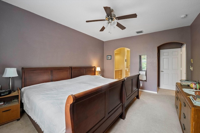 bedroom featuring visible vents, baseboards, ceiling fan, light colored carpet, and arched walkways