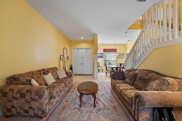 living area featuring light tile patterned floors, visible vents, stairs, and a notable chandelier