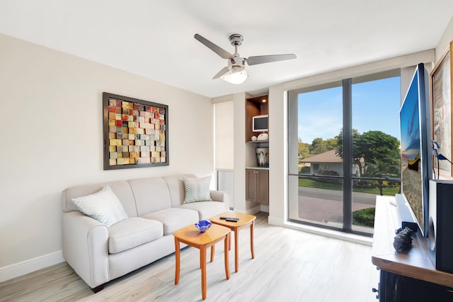 1523 Bridgewood Dr, Boca Raton, FL 33434 - living area featuring light wood finished floors, expansive windows, ceiling fan, and baseboards