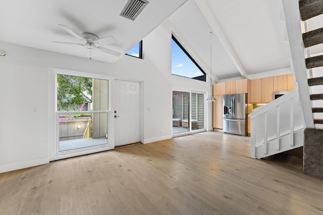 unfurnished living room featuring visible vents, a healthy amount of sunlight, stairway, and light wood-type flooring