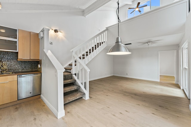 staircase featuring beam ceiling, wood finished floors, a ceiling fan, and baseboards