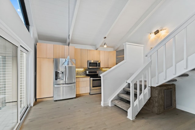 kitchen featuring light brown cabinets, beam ceiling, decorative backsplash, light wood-style flooring, and appliances with stainless steel finishes