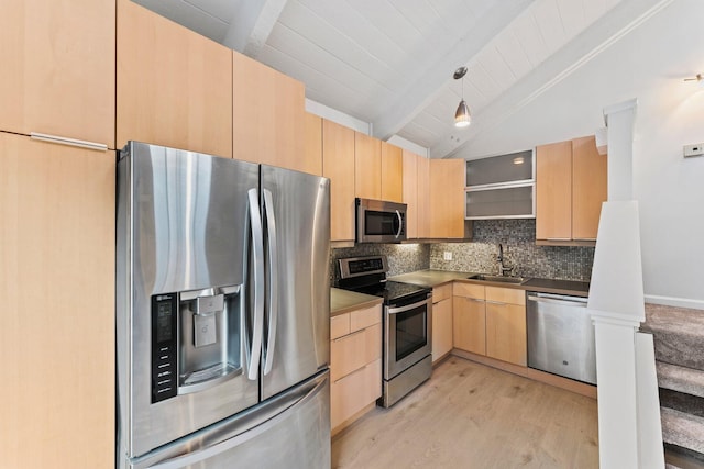 kitchen featuring tasteful backsplash, vaulted ceiling with beams, light brown cabinetry, stainless steel appliances, and a sink