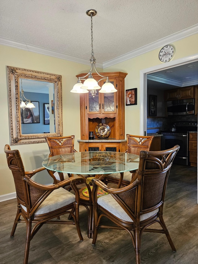 dining room with dark wood finished floors, a textured ceiling, an inviting chandelier, and ornamental molding