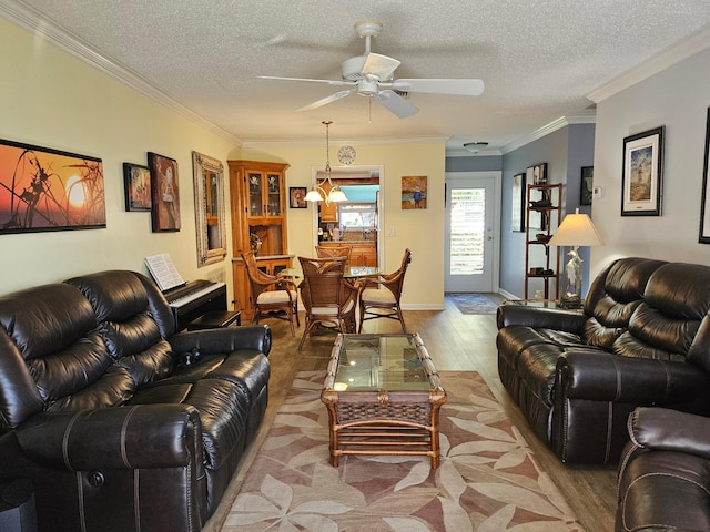 living area featuring a textured ceiling, a ceiling fan, and ornamental molding